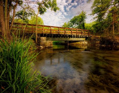 Letort Spring Run flowing under a foot bridge as it winds through a quiet and peaceful meadow. By Jay Himes Photo
