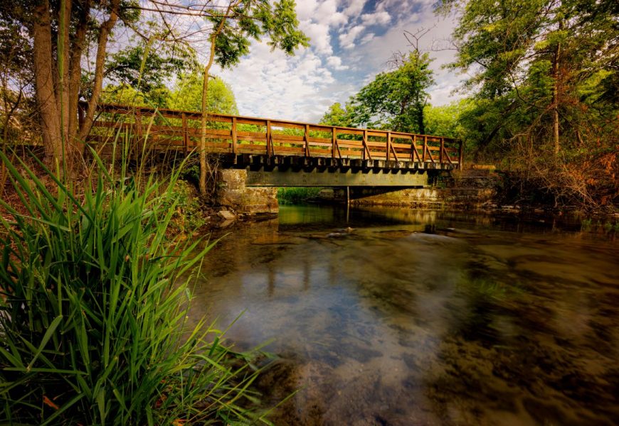 Letort Spring Run flowing under a foot bridge as it winds through a quiet and peaceful meadow. By Jay Himes Photo
